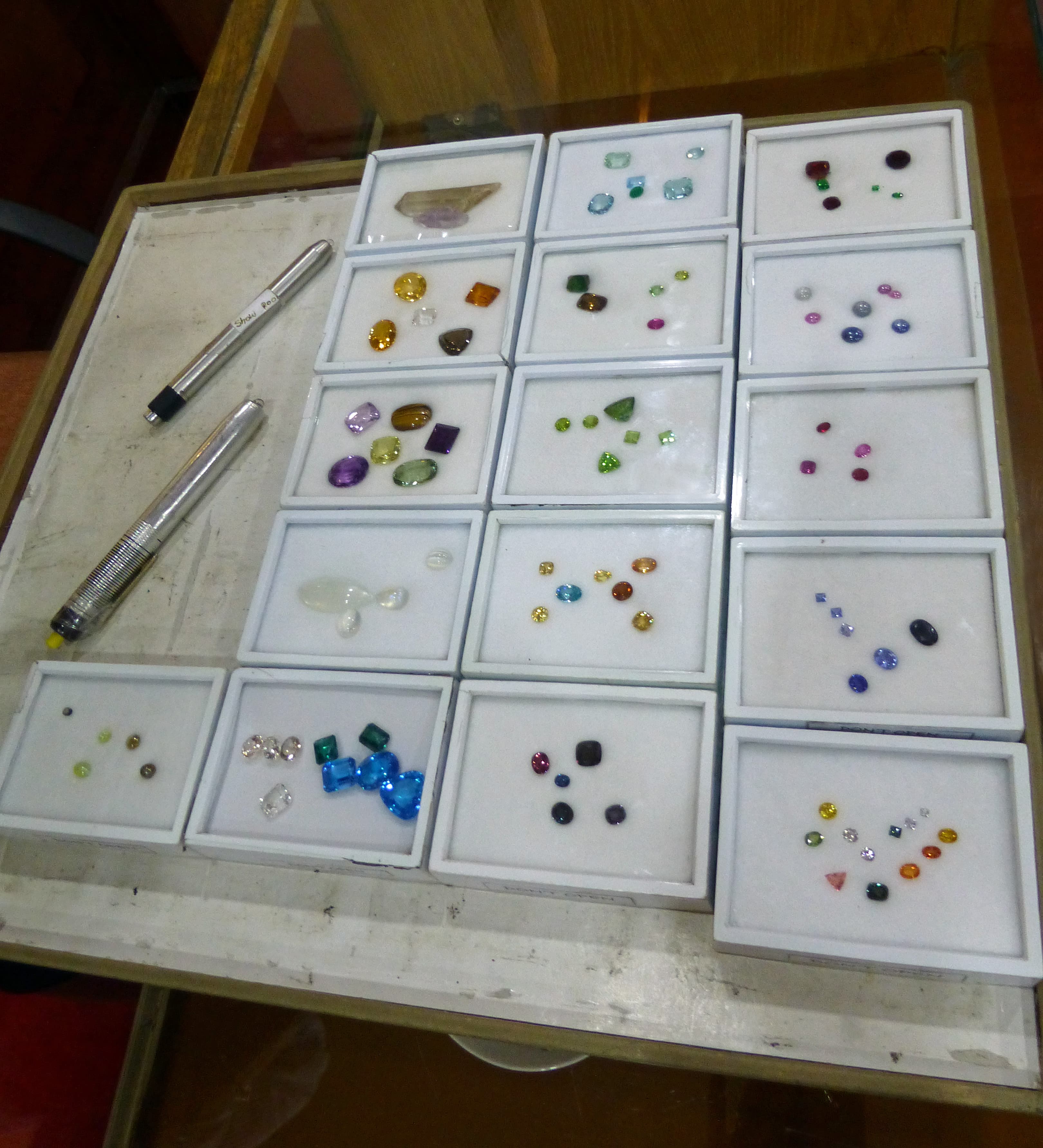 Trays of loose faceted gemstones at a gem trading table in Sri Lanka